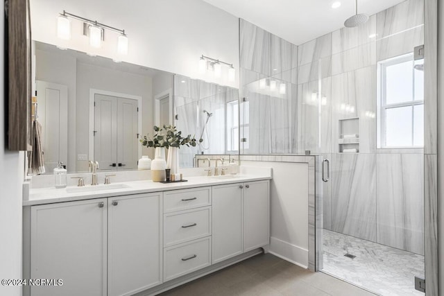 bathroom with a shower with shower door, tile patterned floors, and vanity