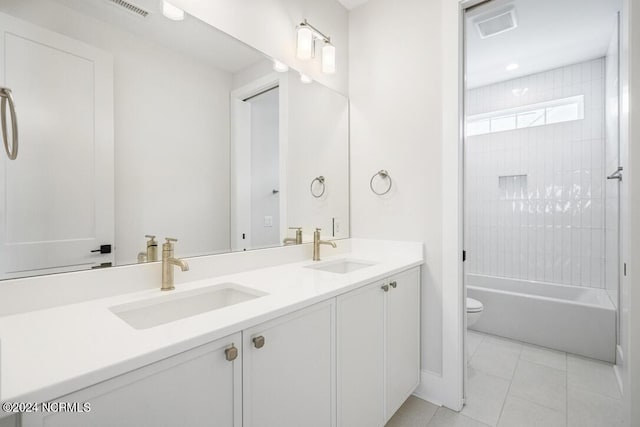 full bathroom featuring vanity, toilet, tiled shower / bath combo, and tile patterned flooring