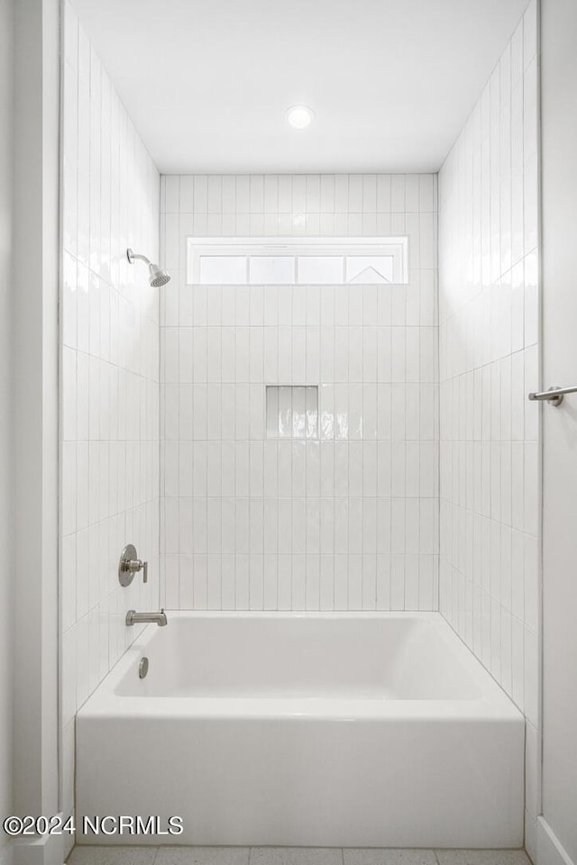 bathroom with a healthy amount of sunlight and tiled shower / bath combo