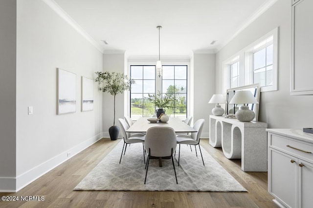 dining area with a wealth of natural light, light hardwood / wood-style flooring, and ornamental molding