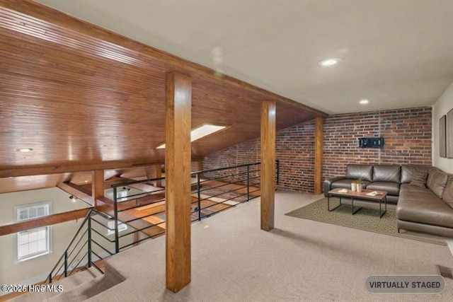 carpeted living room featuring lofted ceiling and brick wall