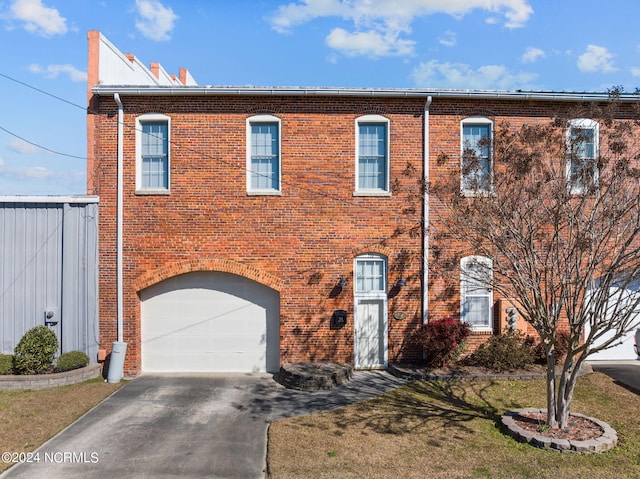 multi unit property with a garage and a front yard