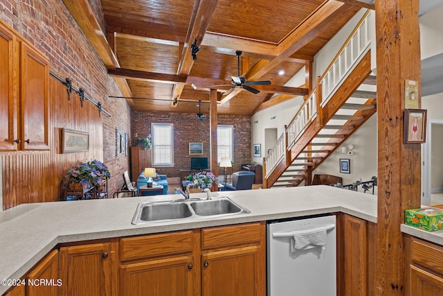 kitchen with brick wall, ceiling fan, sink, beamed ceiling, and dishwasher