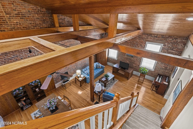 living room with wood ceiling, high vaulted ceiling, wood-type flooring, and brick wall