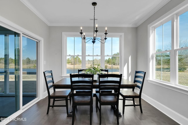 dining space with a wealth of natural light, an inviting chandelier, dark wood-type flooring, and crown molding