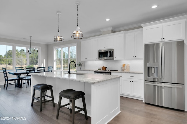 kitchen featuring appliances with stainless steel finishes, tasteful backsplash, white cabinetry, sink, and light wood-type flooring