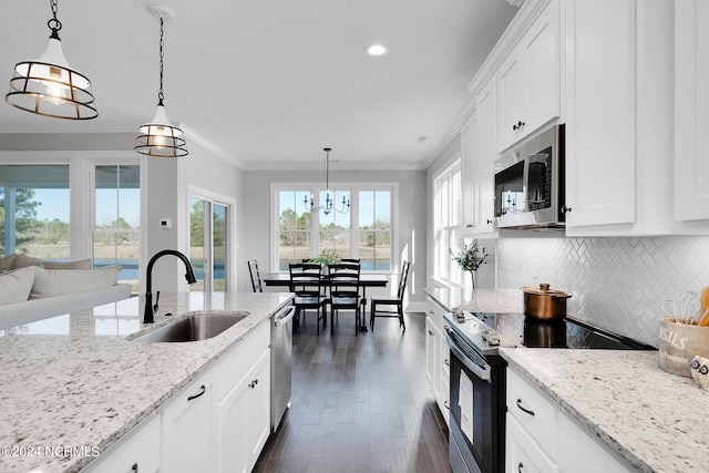 kitchen featuring pendant lighting, dark hardwood / wood-style floors, ornamental molding, stainless steel appliances, and tasteful backsplash