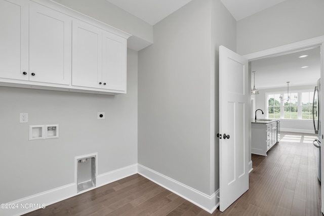 clothes washing area featuring cabinets, sink, a chandelier, dark hardwood / wood-style floors, and hookup for an electric dryer