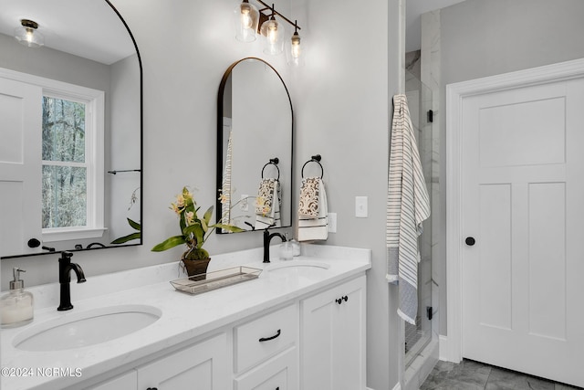 bathroom with a shower with door, tile floors, oversized vanity, and double sink