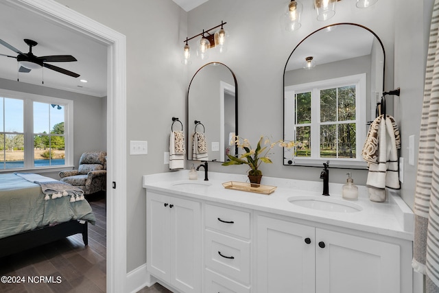 bathroom with oversized vanity, ceiling fan, hardwood / wood-style flooring, and dual sinks