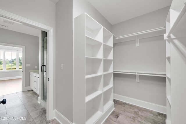 walk in closet with light tile floors