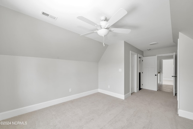 additional living space with light carpet, vaulted ceiling, and ceiling fan