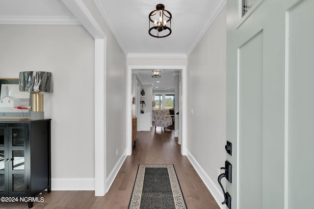 corridor featuring crown molding, dark hardwood / wood-style flooring, and a notable chandelier