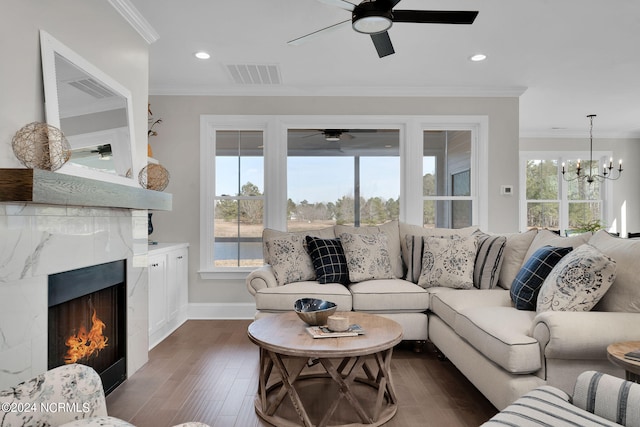 living room featuring ceiling fan with notable chandelier, crown molding, dark hardwood / wood-style flooring, and a fireplace