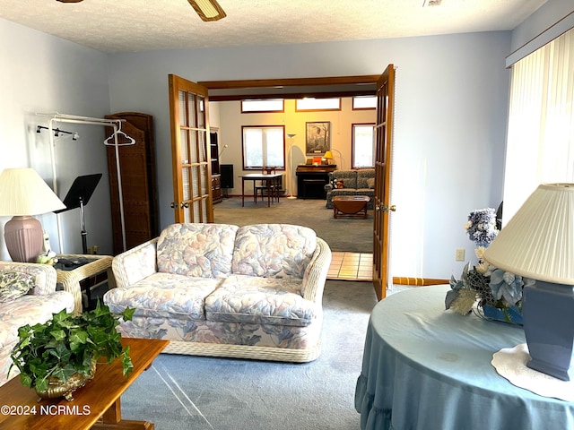 carpeted living room with ceiling fan and a textured ceiling