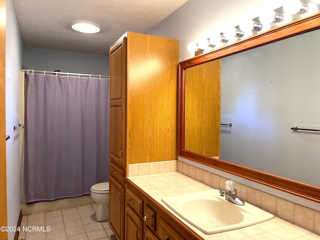 bathroom featuring tile floors, a textured ceiling, toilet, and vanity