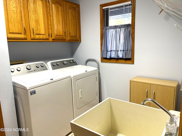 washroom featuring cabinets, washer and dryer, and sink