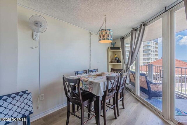 dining room with light hardwood / wood-style floors and a textured ceiling