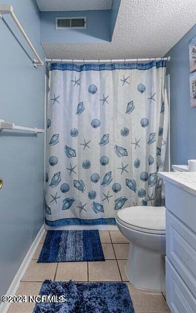 bathroom with vanity, a textured ceiling, tile floors, and toilet