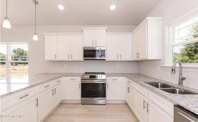 1204 Opaca Dr SE, Bolivia, NC 28422 - kitchen featuring appliances with stainless steel finishes, a sink, white cabinetry, light wood finished floors, and light stone counters