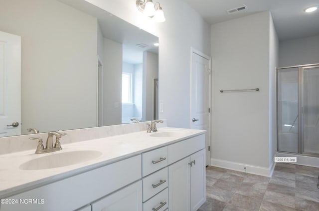 full bathroom with double vanity, a sink, visible vents, and a shower stall