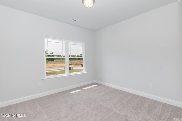 carpeted empty room featuring visible vents and baseboards