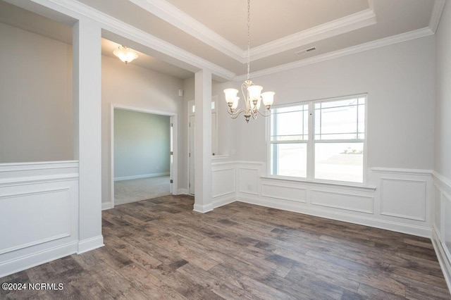 unfurnished dining area featuring a tray ceiling, a notable chandelier, ornamental molding, and dark hardwood / wood-style flooring