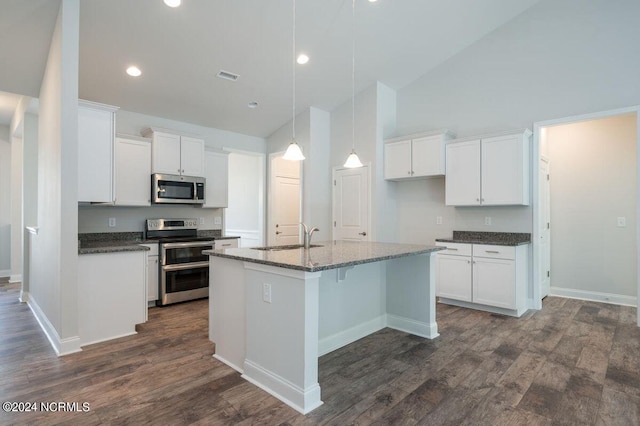 kitchen with visible vents, appliances with stainless steel finishes, a kitchen island with sink, a sink, and white cabinetry