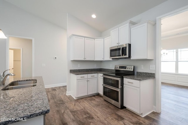 kitchen featuring lofted ceiling, white cabinets, stainless steel appliances, and a sink