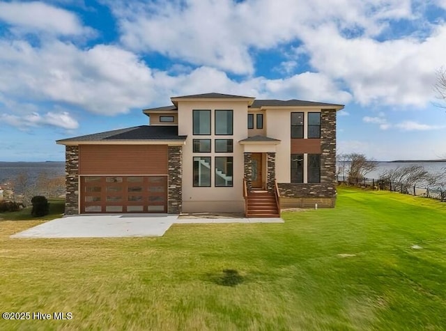 rear view of property with an attached garage, a yard, stone siding, concrete driveway, and stucco siding