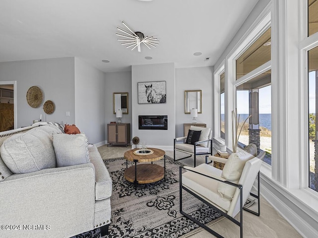 living area featuring a glass covered fireplace, visible vents, and baseboards