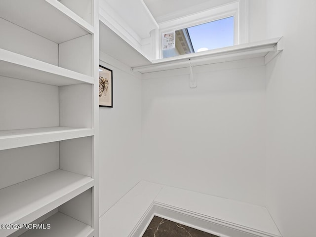 walk in closet with marble finish floor