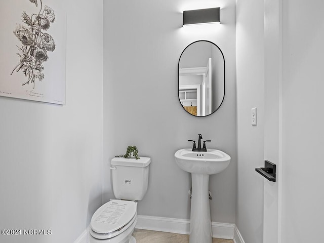 bathroom featuring baseboards, a sink, and toilet