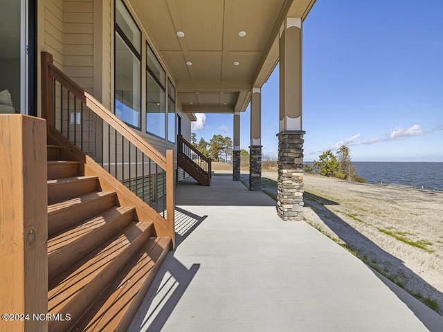 view of patio / terrace featuring a water view and stairs