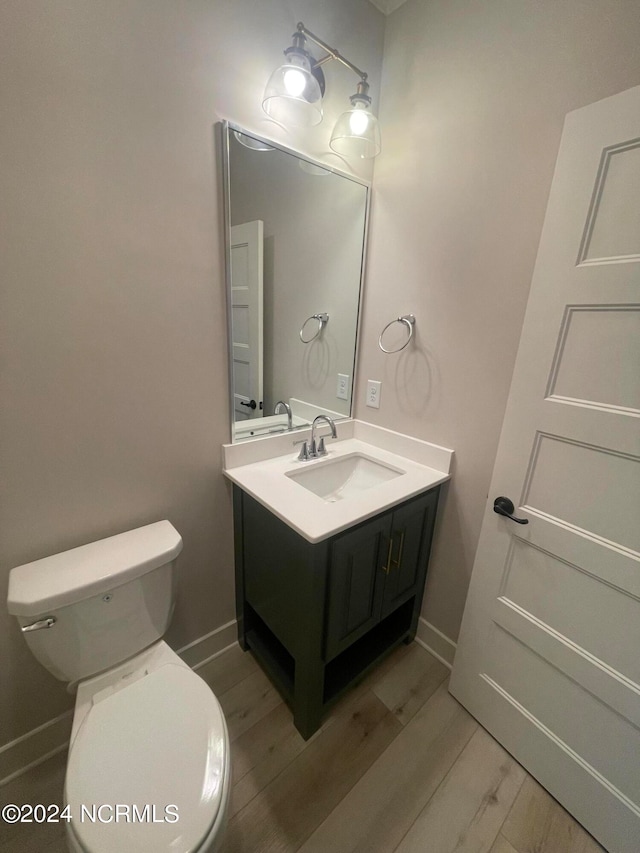 bathroom featuring vanity, toilet, and hardwood / wood-style floors