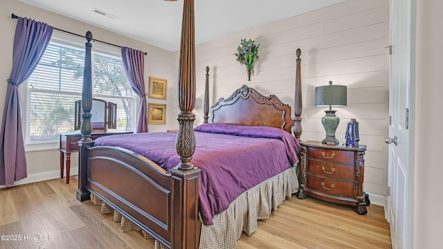 bedroom with visible vents, baseboards, and wood finished floors