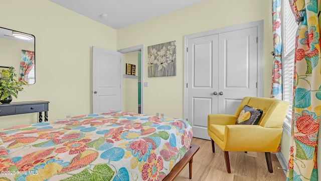 bedroom featuring a closet, wood finished floors, and multiple windows