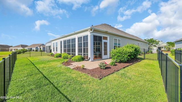 rear view of house featuring a lawn and a fenced backyard