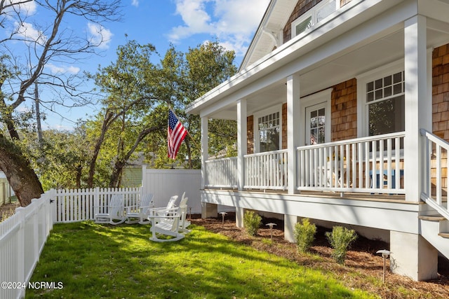 view of side of home featuring a porch and a yard