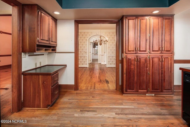 kitchen with dishwasher, hardwood / wood-style floors, hanging light fixtures, and a notable chandelier