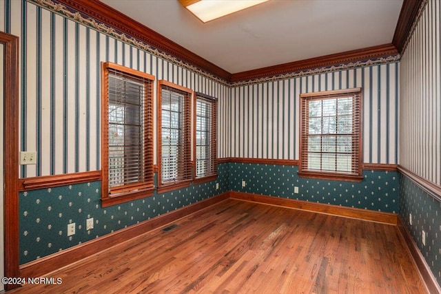 empty room with hardwood / wood-style floors and ornamental molding