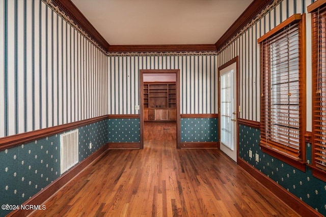 spare room featuring hardwood / wood-style flooring and crown molding