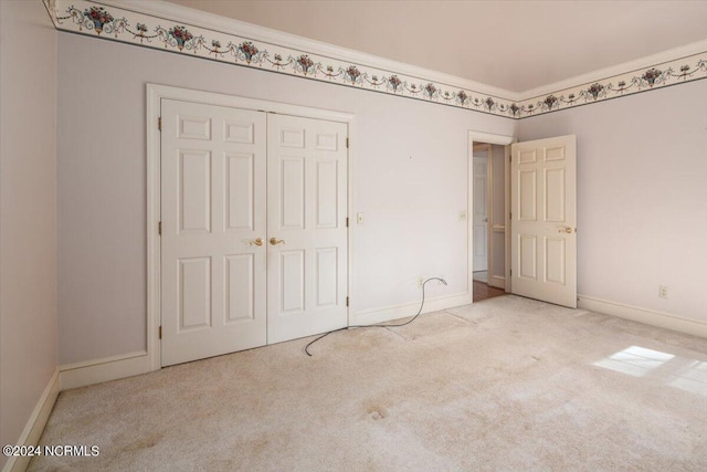 unfurnished bedroom featuring light colored carpet and a closet