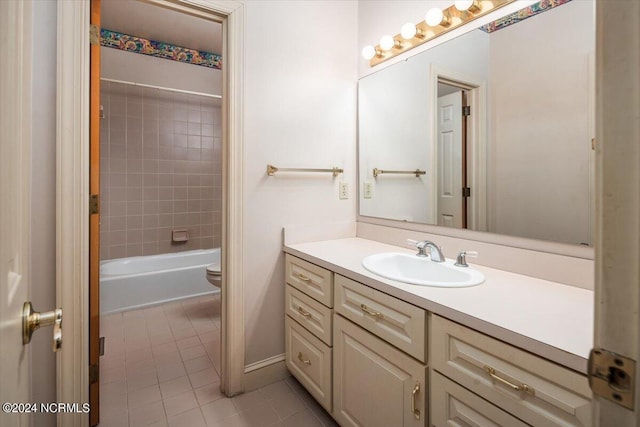 full bathroom with tile patterned floors, vanity, tiled shower / bath combo, and toilet