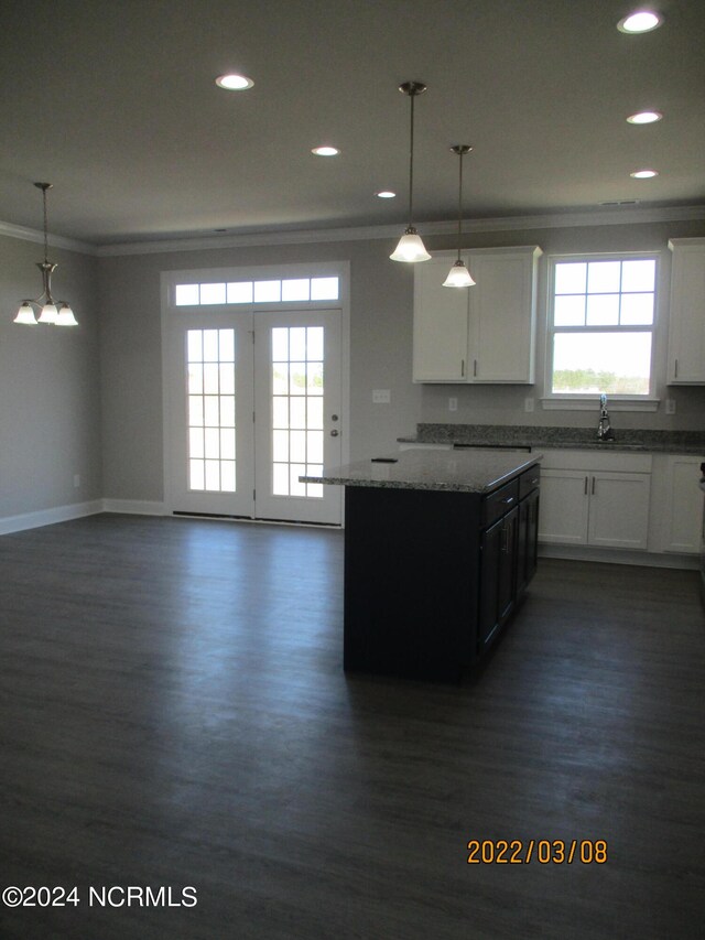 kitchen with white cabinetry, decorative light fixtures, dark wood-type flooring, a chandelier, and ornamental molding