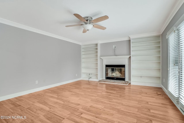 unfurnished living room with ceiling fan, light wood-type flooring, a brick fireplace, and a wealth of natural light