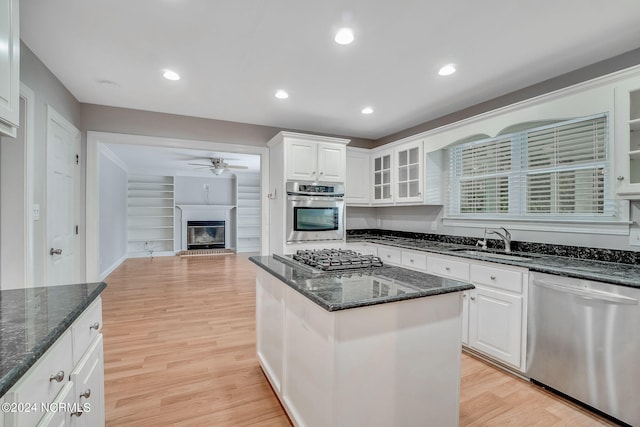 kitchen featuring ceiling fan, sink, stainless steel appliances, and light wood-type flooring