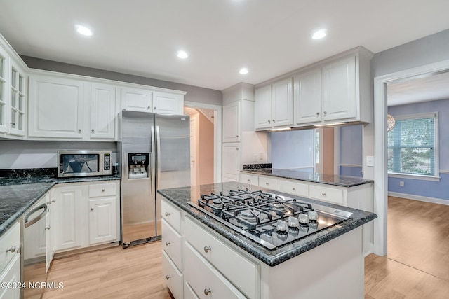 kitchen with a kitchen island, light hardwood / wood-style floors, white cabinets, and appliances with stainless steel finishes