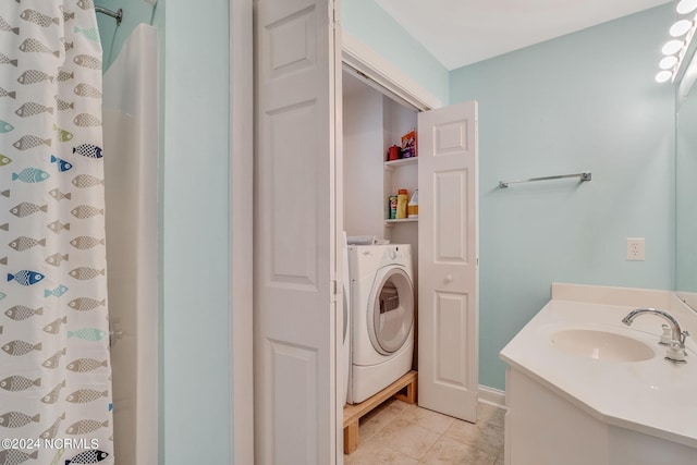 bathroom featuring oversized vanity, washer / dryer, and tile flooring