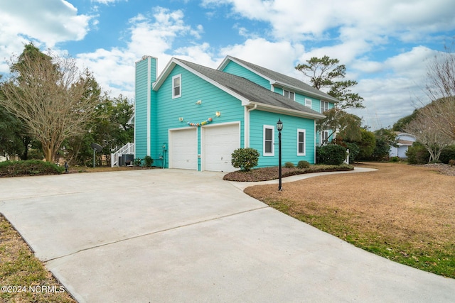 view of property featuring a front lawn and a garage